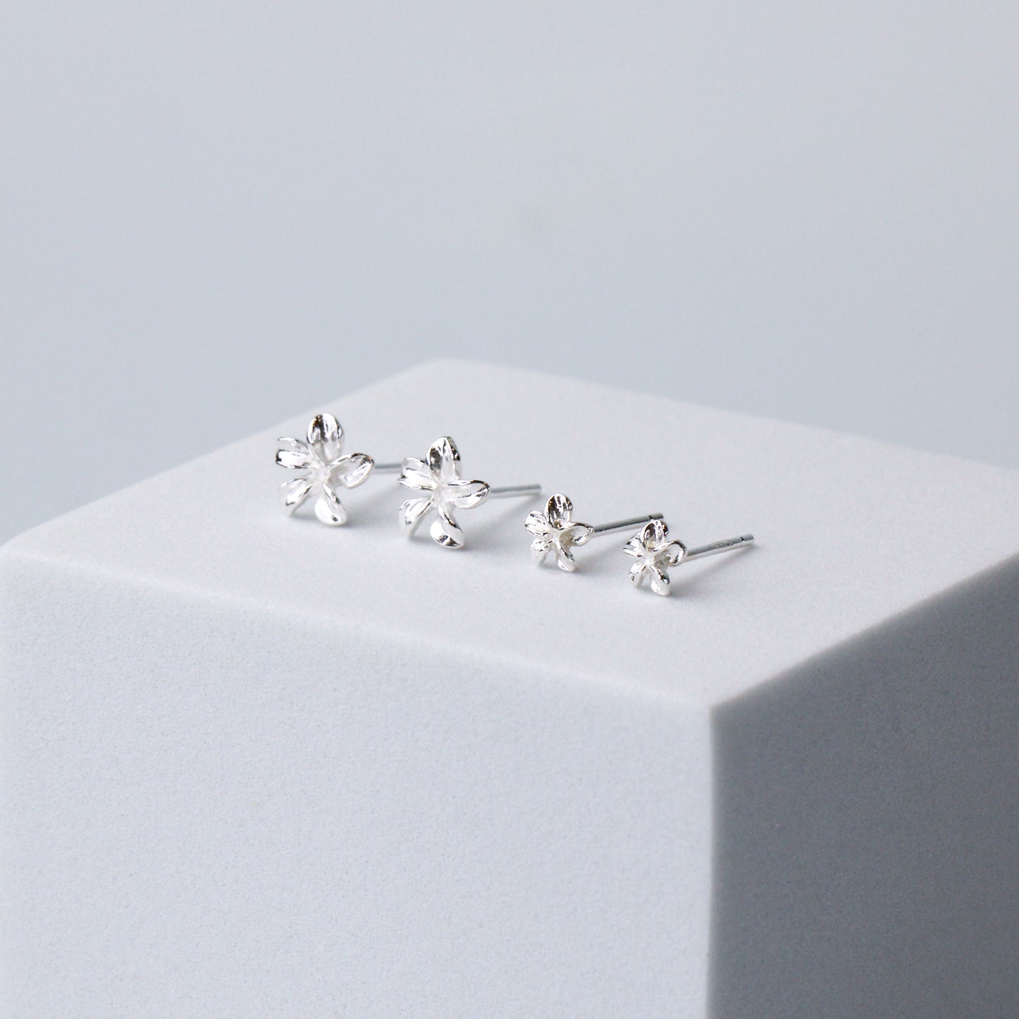 Two pairs of sterling silver flower stud earrings, in two different size options