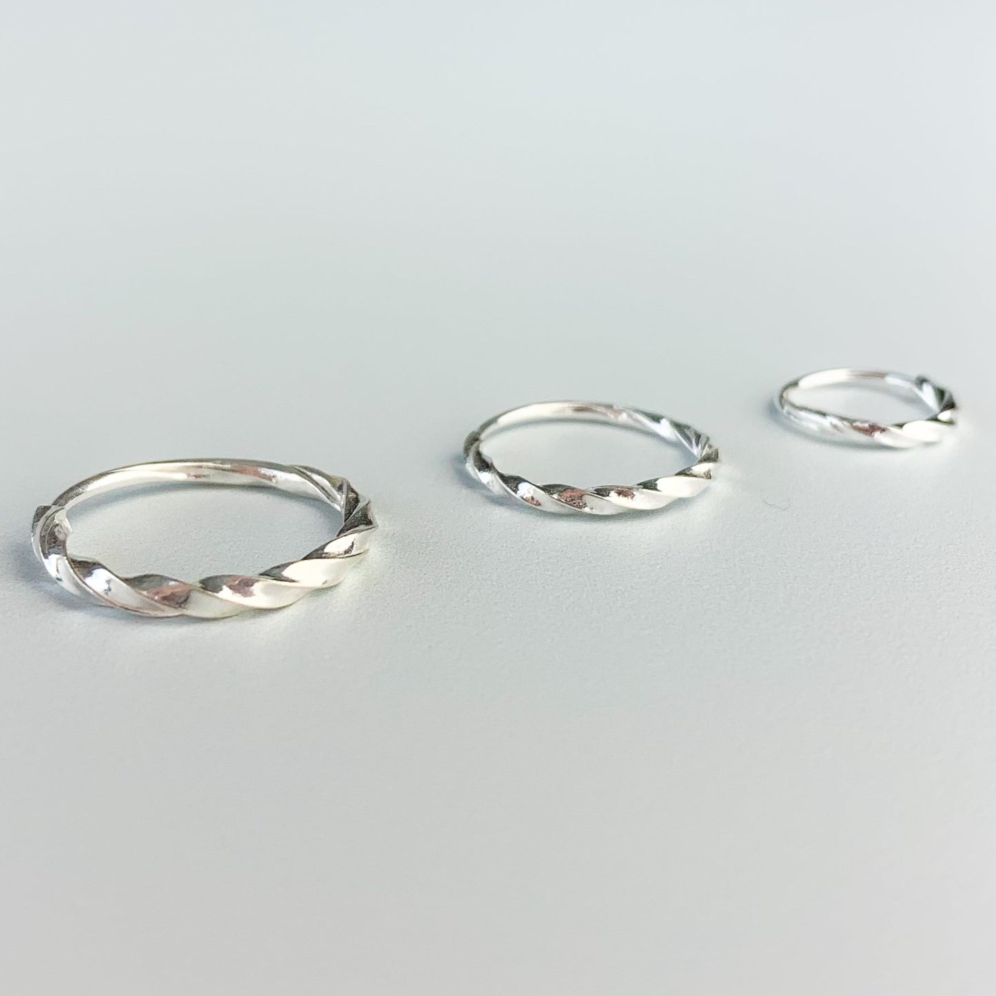 Twisted silver hoop earrings with a sleeper fastening, in three sizes