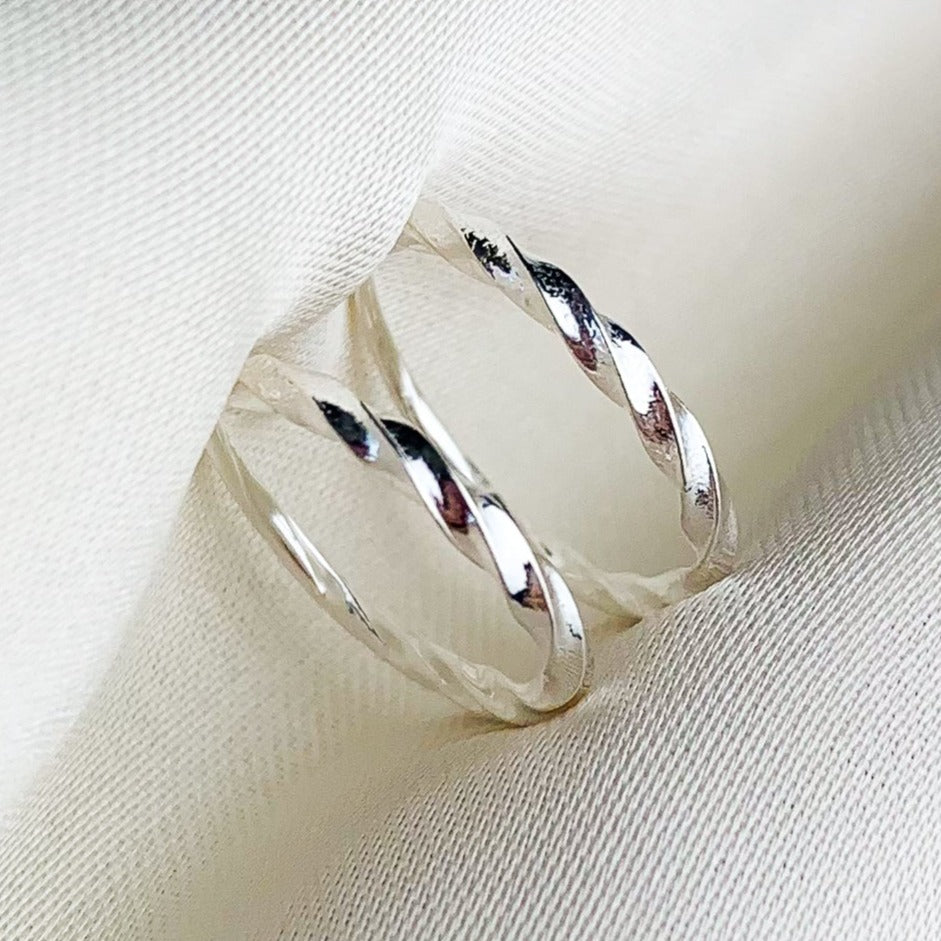 Twisted silver hoop earrings with a sleeper fastening.