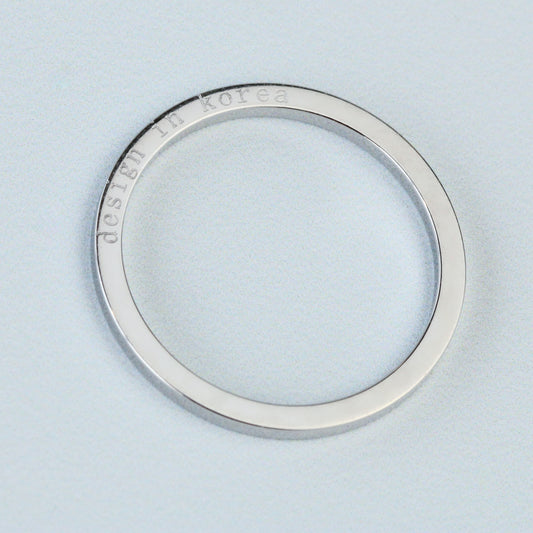 Silver ring with 'Dedicated to Korea' engraving on a light blue background