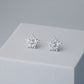 Silver snowflake shape stud earrings with a white crystal detail in the centre.