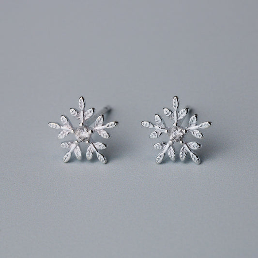 Silver snowflake shape stud earrings with a white crystal detail in the centre.