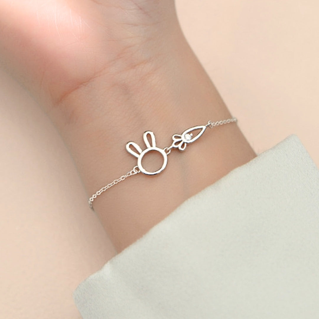 Silver bracelet with a bunny design on a wrist against a light background