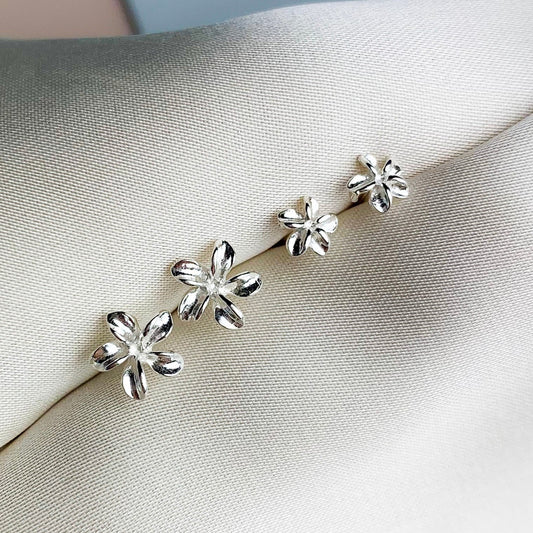 Two pairs of sterling silver flower stud earrings, in two different size options. They have a 3D moulded flower shape.
