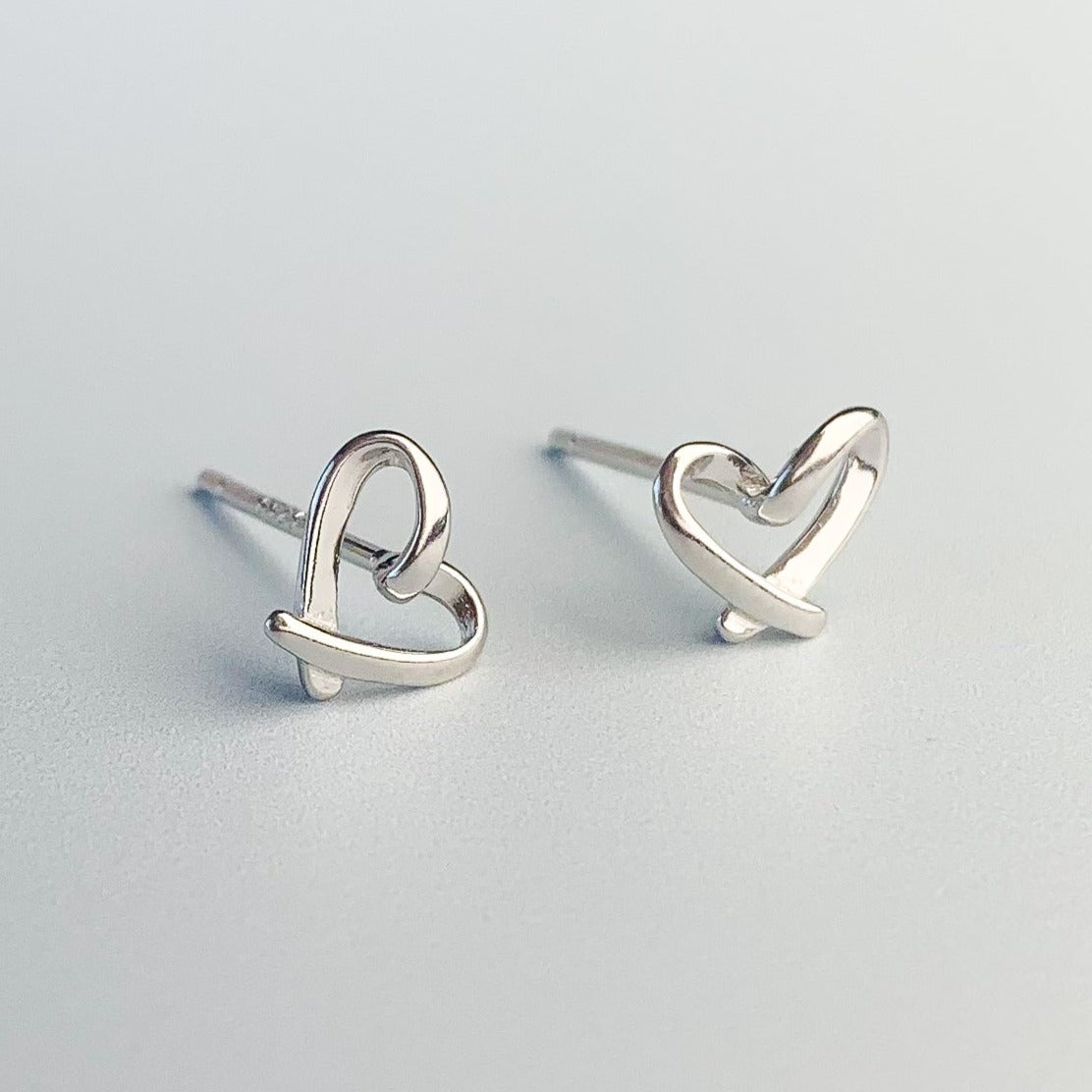 Close up of silver heart stud earrings